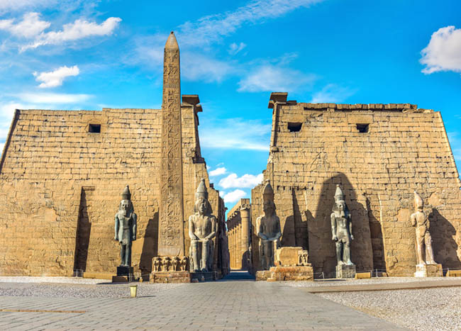 Entrance to egyptian Luxor Temple and blue cloudy sky